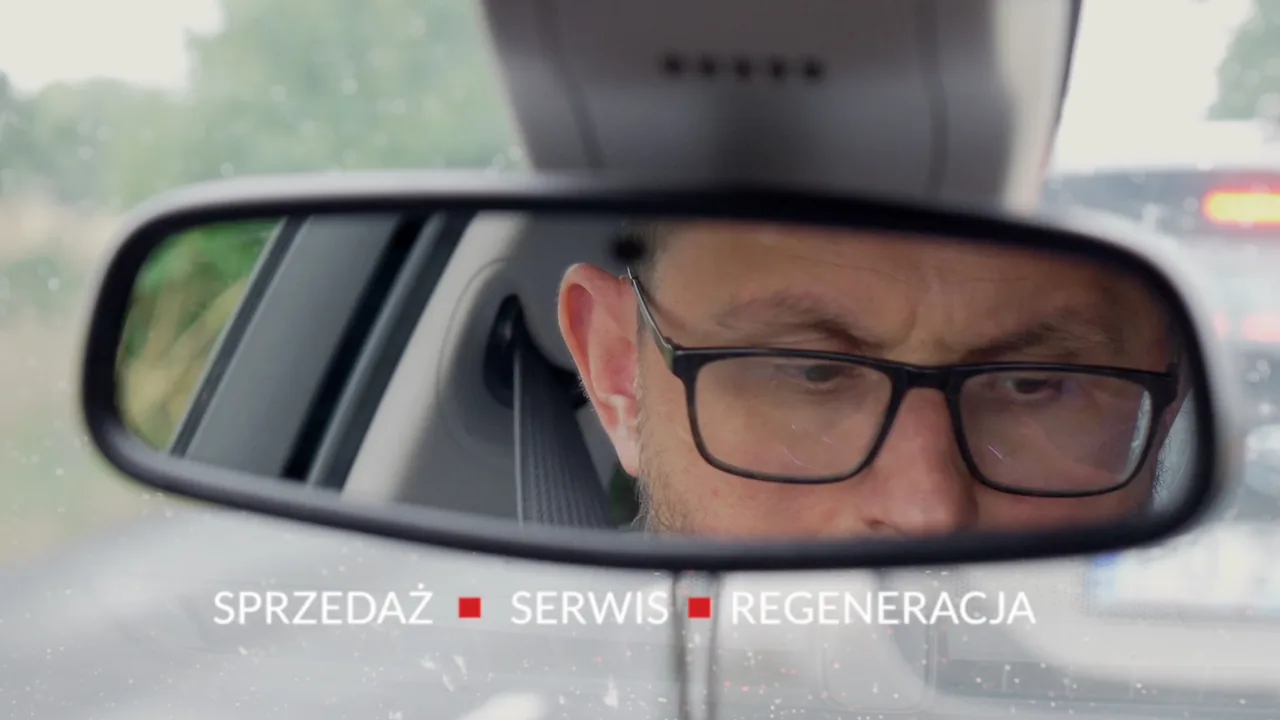 Kierowca widoczny w lusterku samochodu — kadr z reklamy TV firmy Kaliński